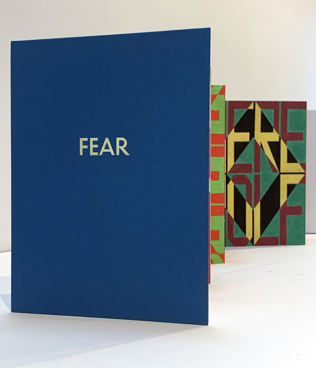 Accordion folded book showing gold stamped cover FEAR